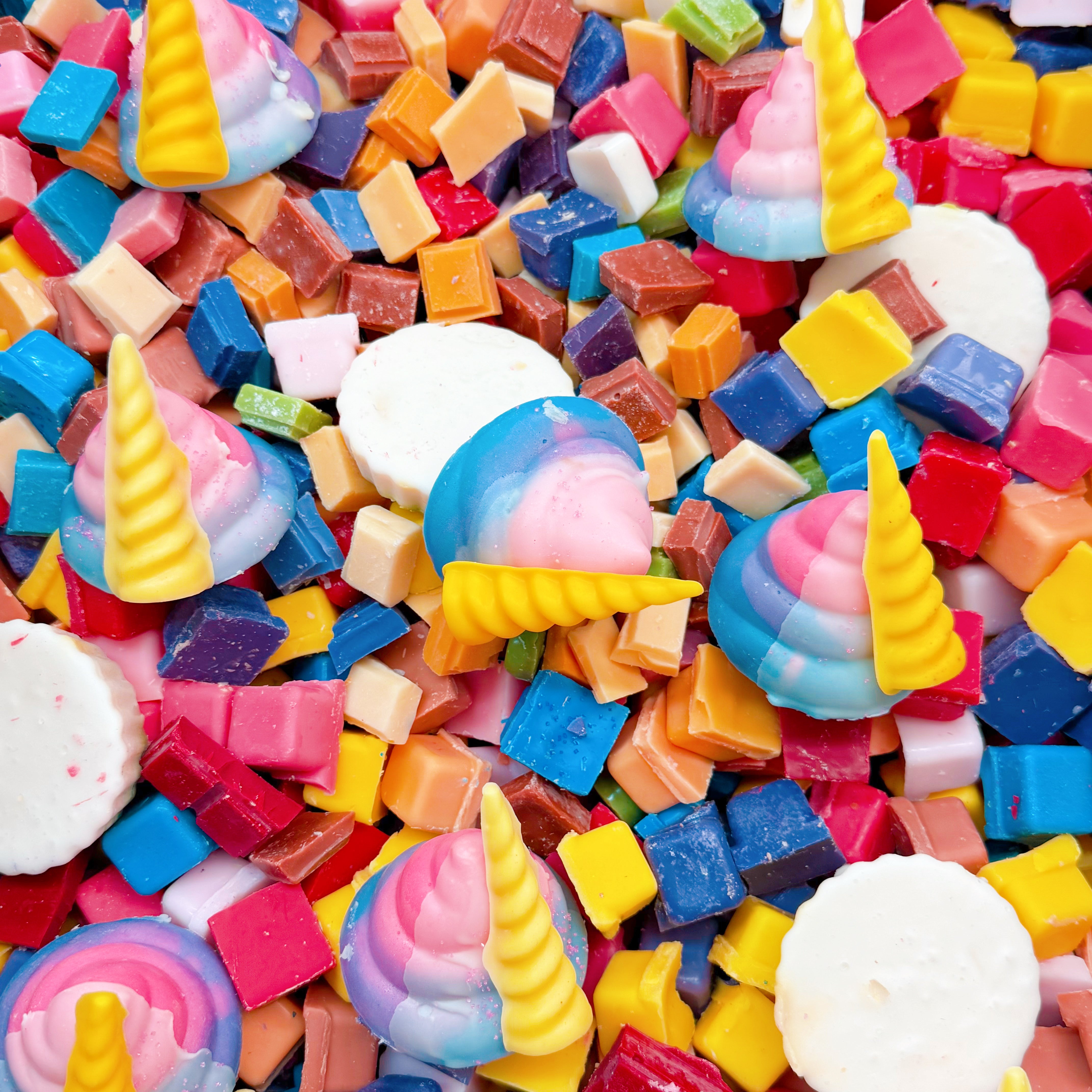 Colorful assorted wax chunks with swirled pastel unicorn horn shapes and white circular discs.